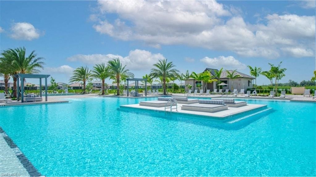 a large swimming pool with palm trees in the background