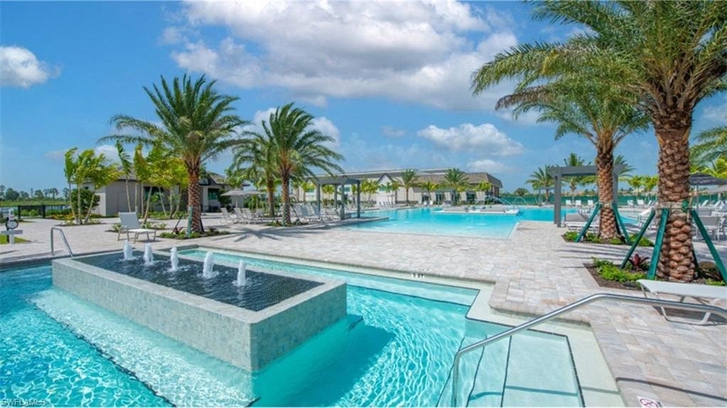 a large swimming pool with palm trees and chairs around it