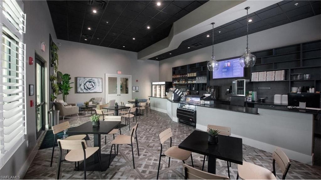 a large dining room with tables and chairs and a kitchen