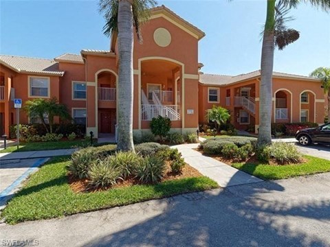 an orange house with palm trees in front of it