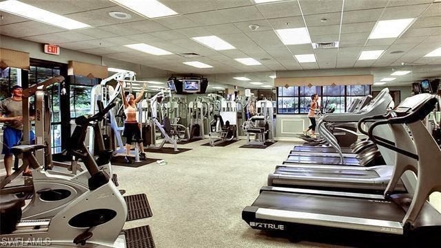 a gym with a lot of exercise equipment and people in it