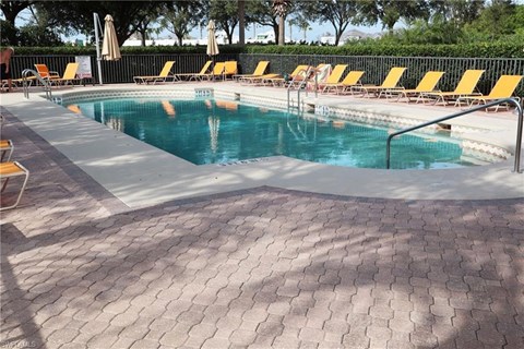 a swimming pool with yellow chairs and a resort style pool