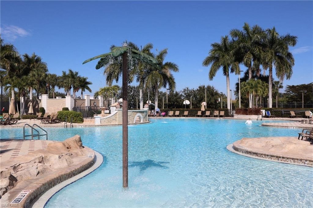 a large swimming pool with palm trees