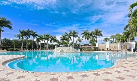 a large swimming pool with palm trees around it