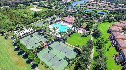an aerial view of a resort with tennis courts and a pool
