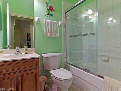 a bathroom with a toilet and a shower and a sink