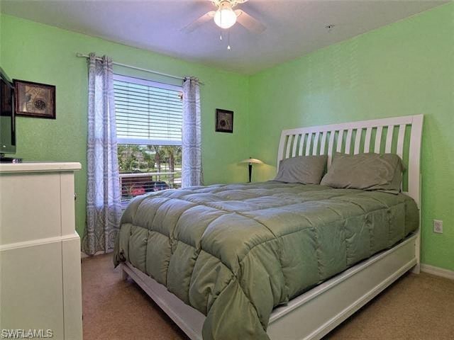 a green bedroom with a bed and a ceiling fan