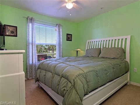 a green bedroom with a bed and a ceiling fan
