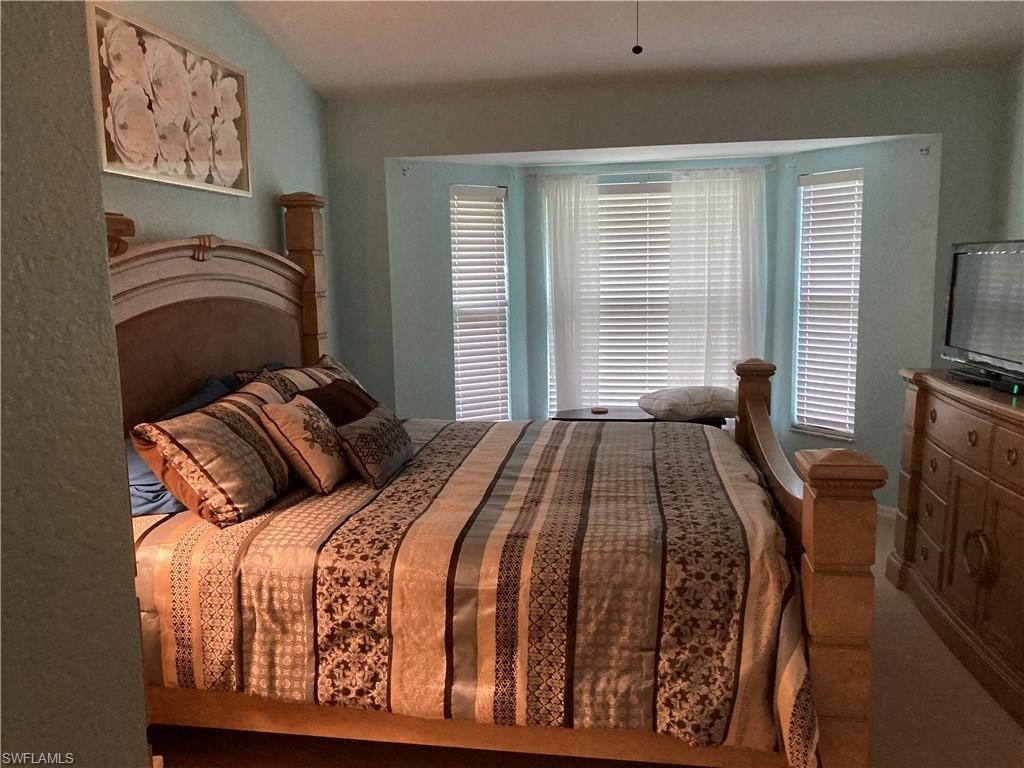 a bedroom with a large bed and a window