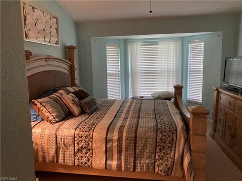 a bedroom with a large bed and a window