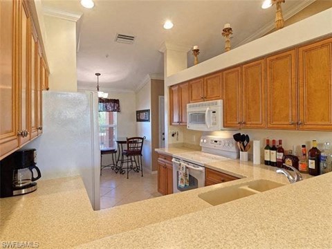 a large kitchen with a sink and a refrigerator