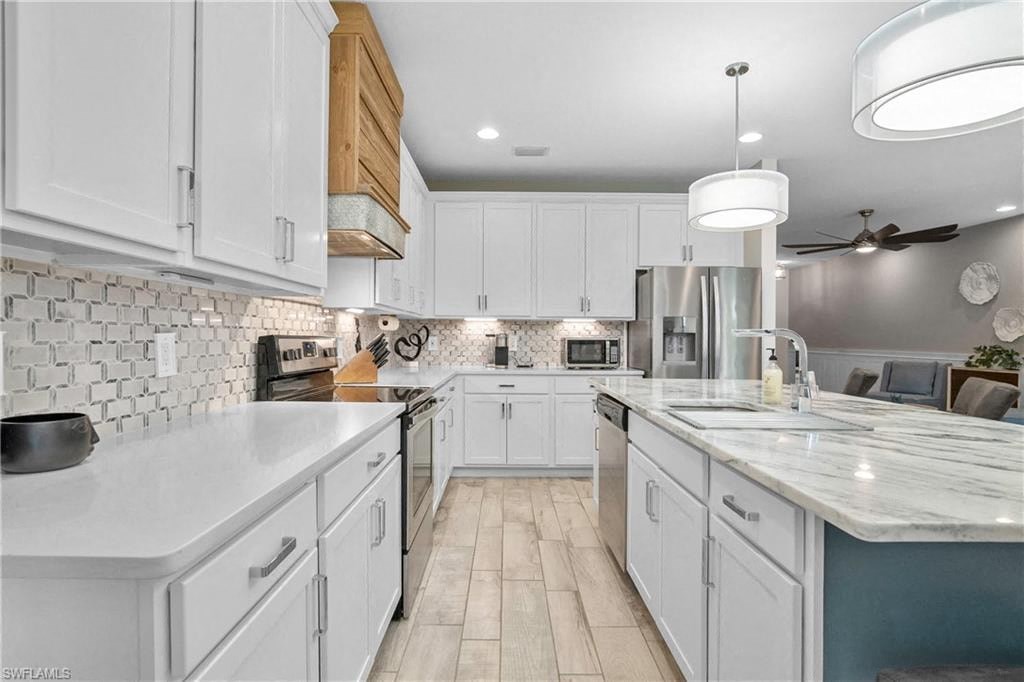 a large white kitchen with white cabinets and a sink