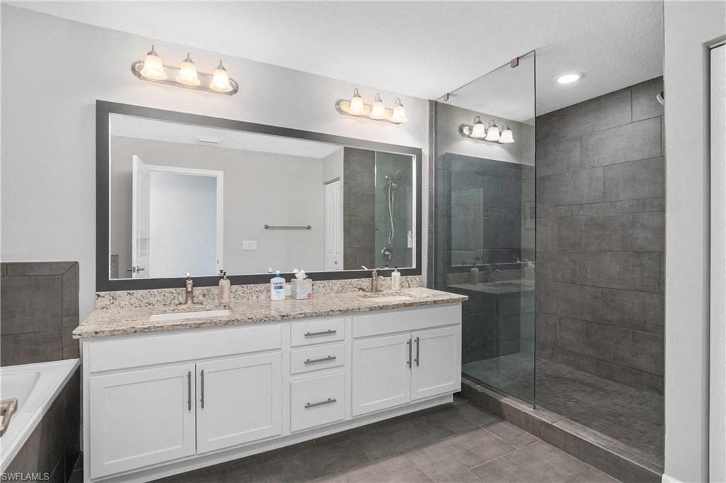 a bathroom with a sink and a shower and a mirror