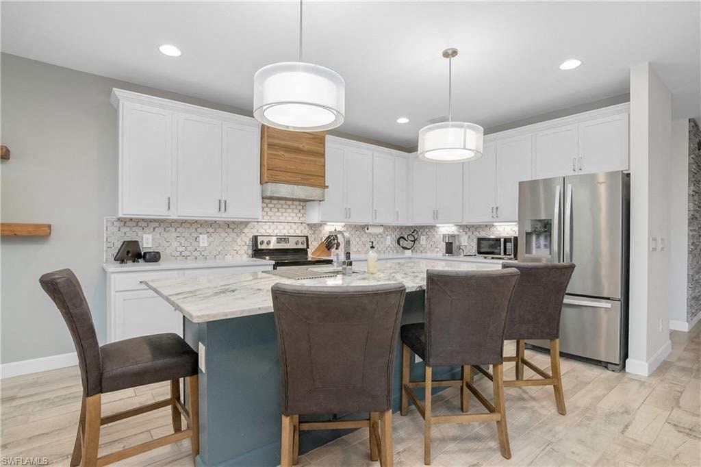 a kitchen with a large island with three chairs