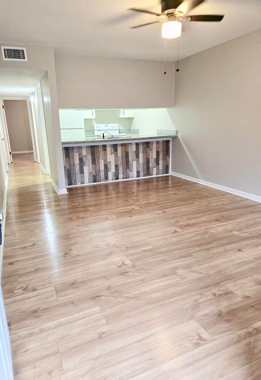 an empty living room with a wooden floor