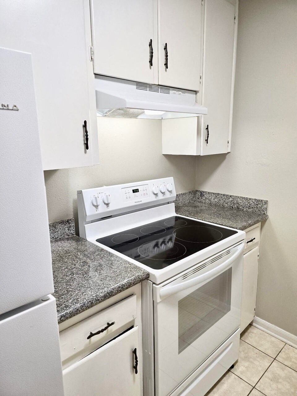 a kitchen with white appliances and granite counter tops