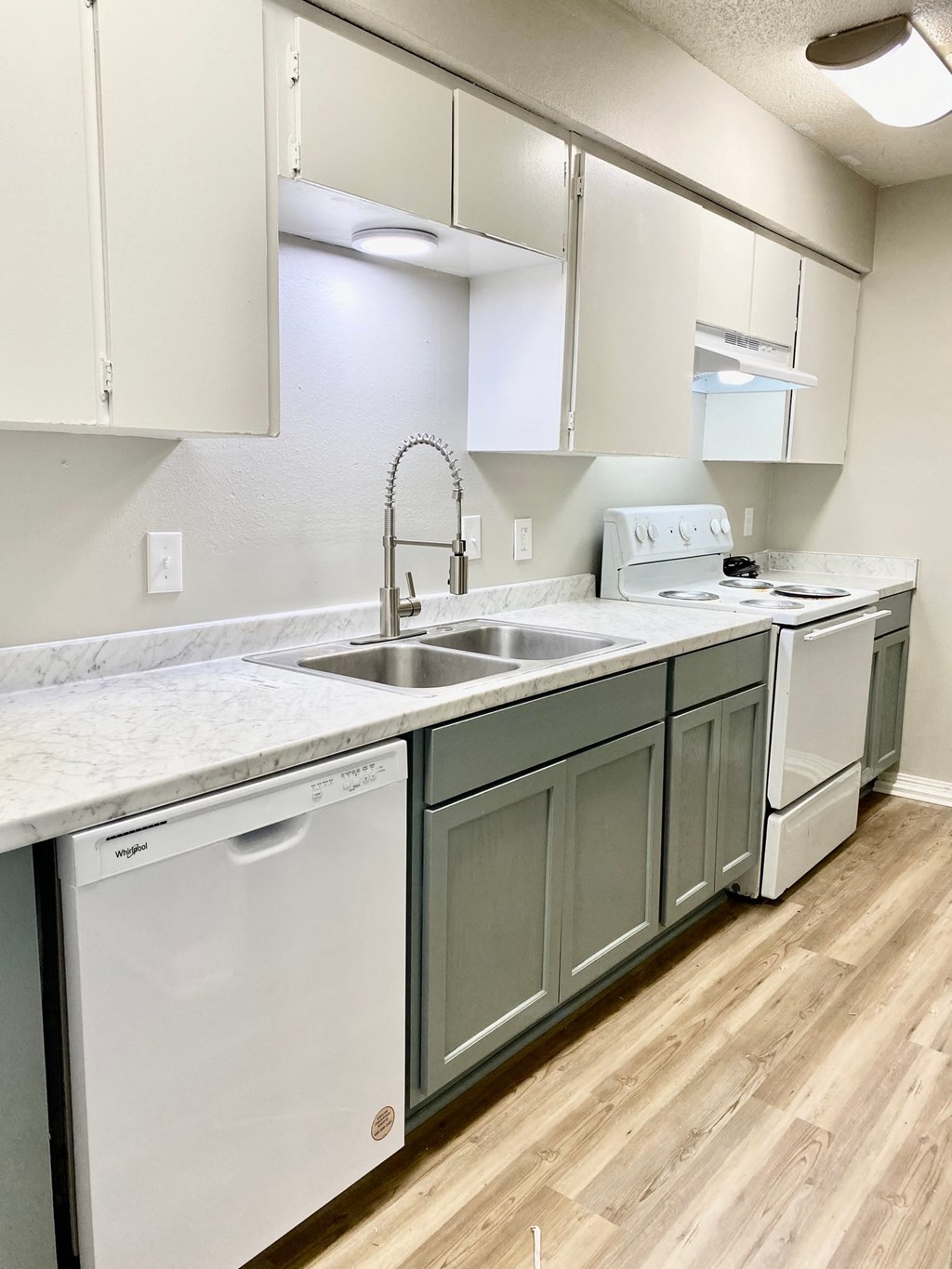 A kitchen with white appliances and green cabinets.