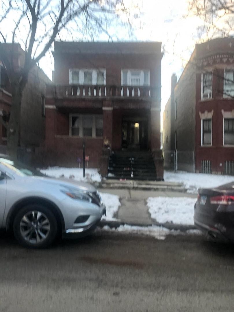 an image of a house with cars parked in front of it