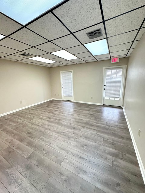 an empty room with wood floors and a door