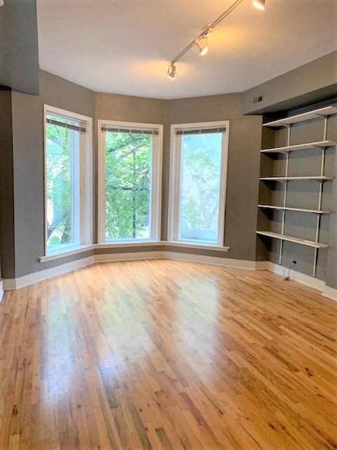 a living room with a hard wood floor and a large window