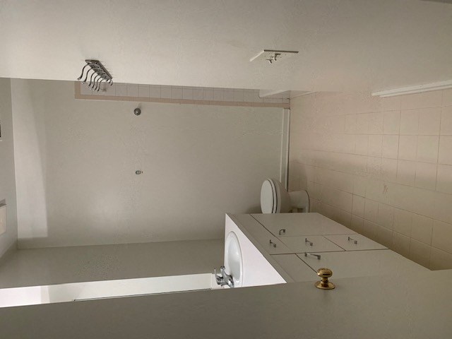 a white bathroom with a toilet and a sink