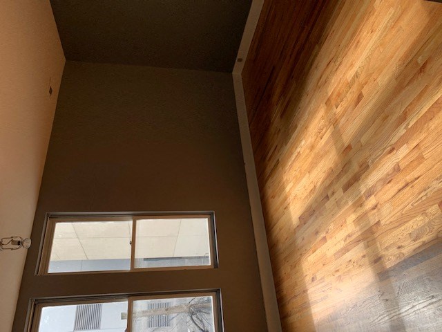 the ceiling of a room with a window and a wooden wall