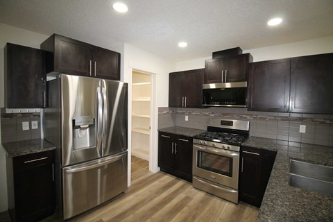 a kitchen with stainless steel appliances and black cabinets