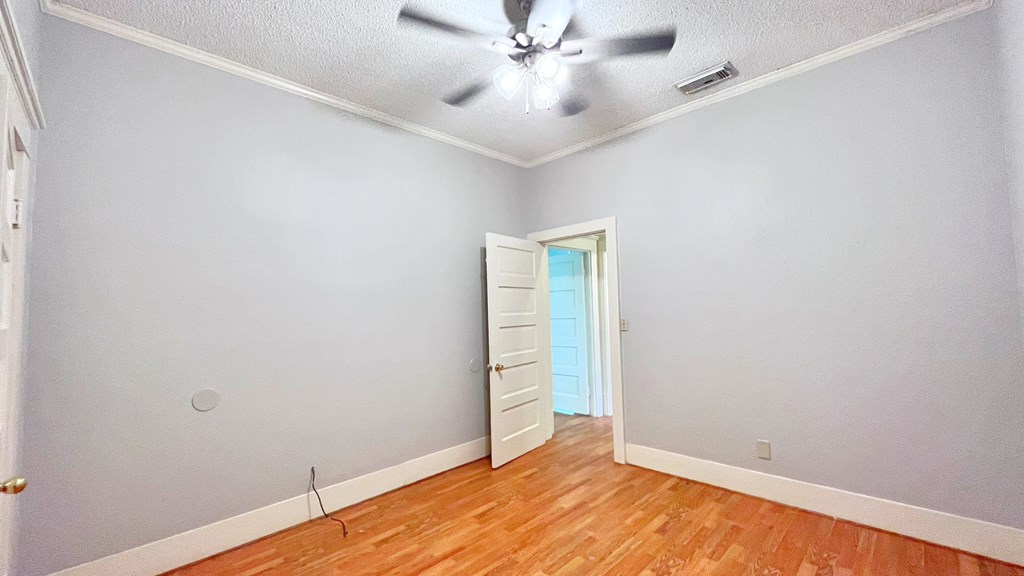 an empty room with a ceiling fan and a door to a closet