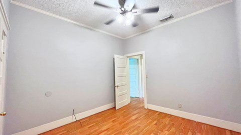 an empty room with a ceiling fan and a door to a closet