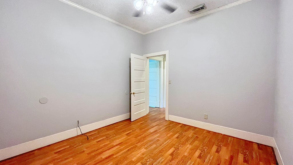the living room of an empty house with wood floors and a white door