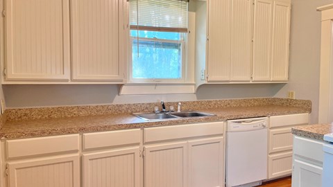 a kitchen with white cabinets and a granite counter top