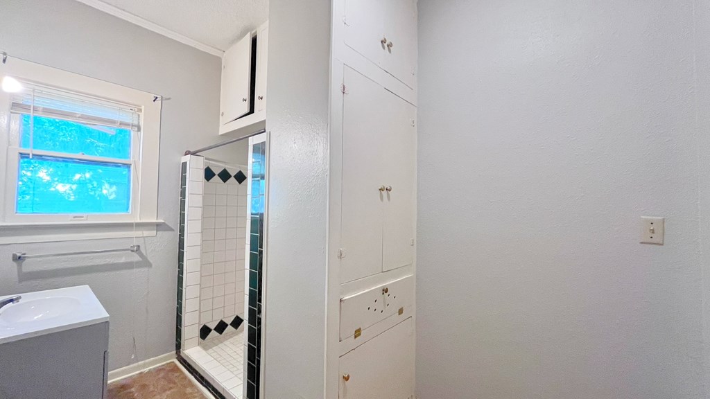 a bathroom with a shower and a sink and a mirror