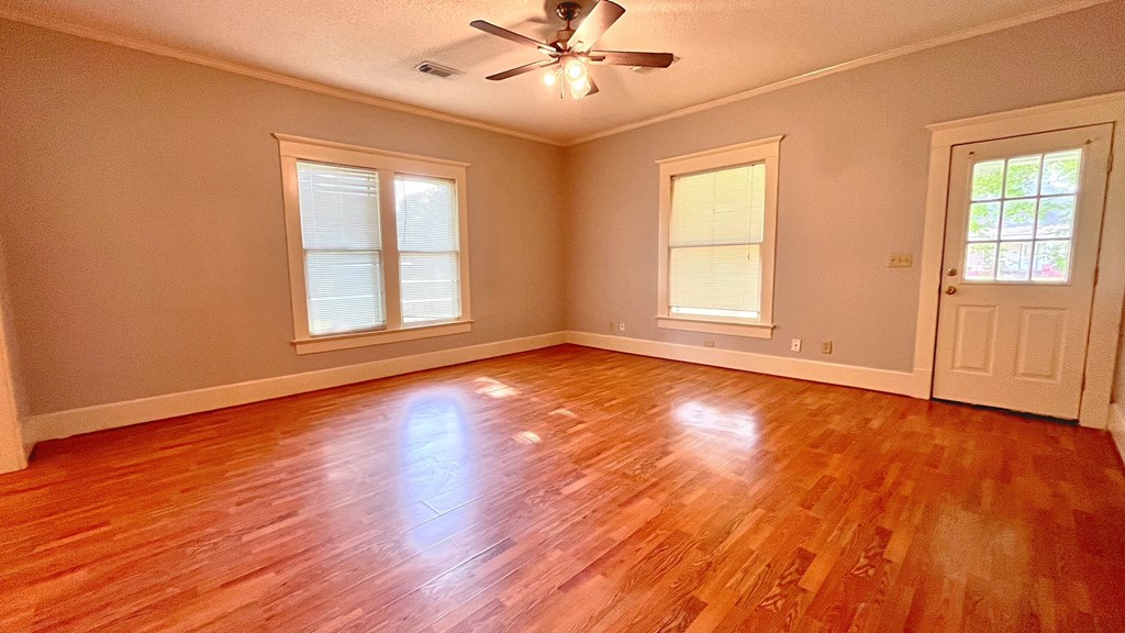a living room with a hard wood floor and a ceiling fan