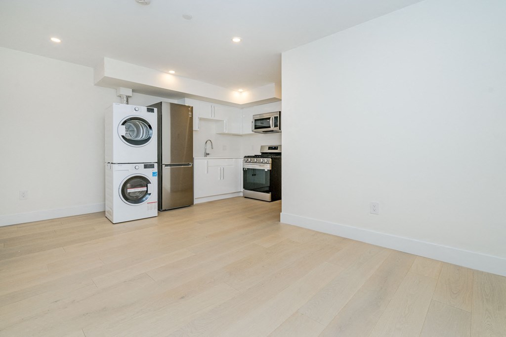 a living room with a refrigerator and a washing machine