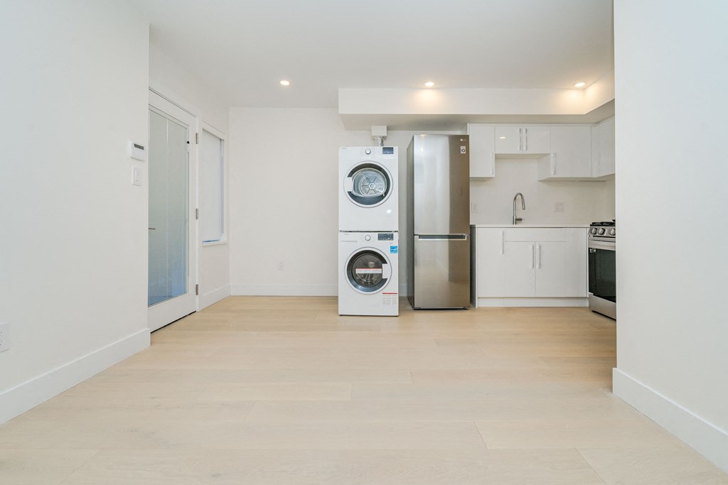 a living room with a refrigerator and a washing machine
