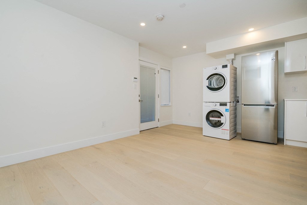 a living room with a refrigerator and a washing machine