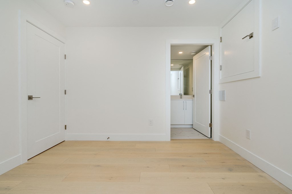 a living room with white walls and a wooden floor