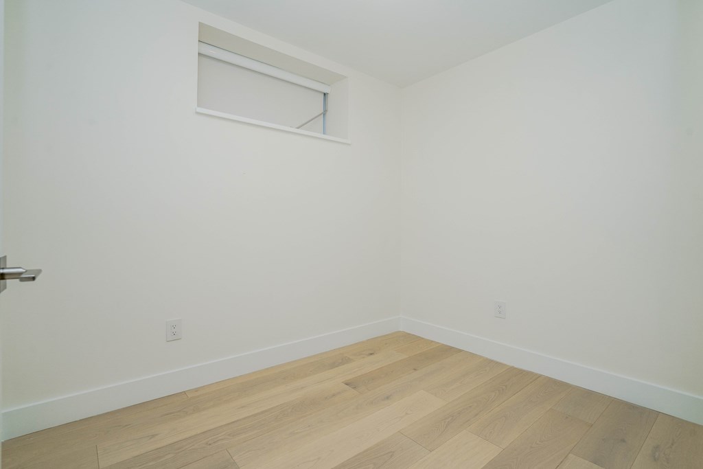 an empty room with white walls and a window
