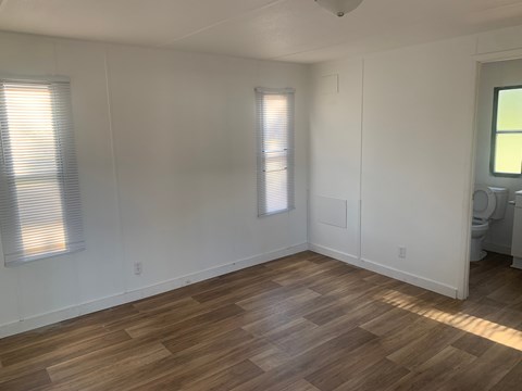 A room with wooden flooring and white walls.