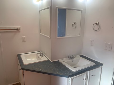 A bathroom with two sinks and a mirror.