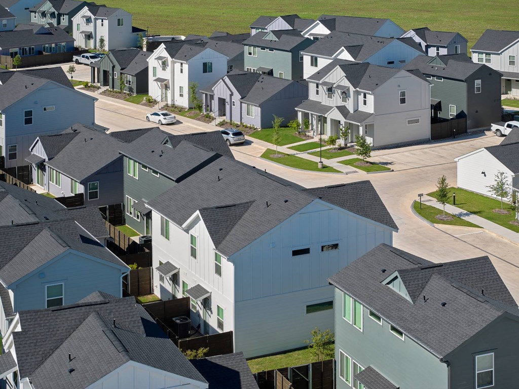 A suburban neighborhood with houses and cars.