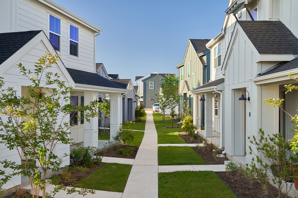 A row of houses with a sidewalk in between.