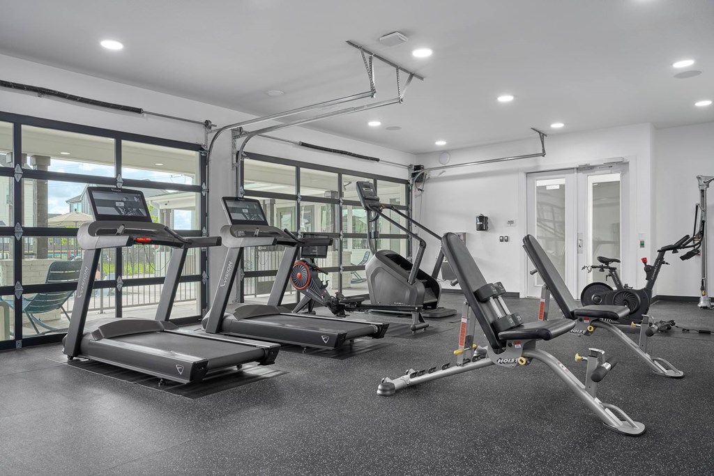 A gym with treadmills, elliptical machines, and other exercise equipment.