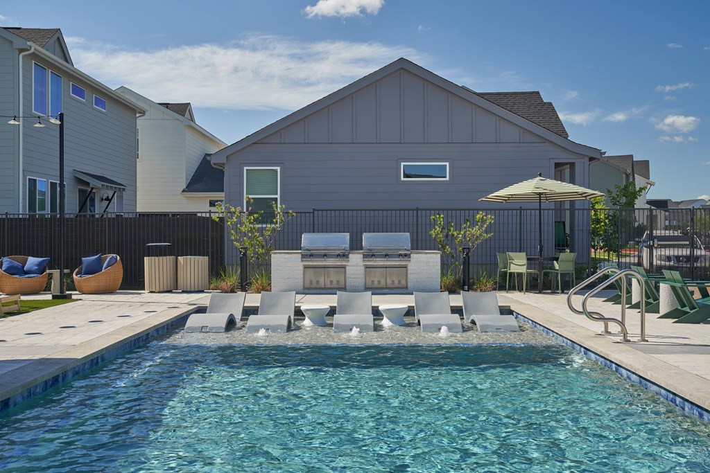 A pool with a slide and a building in the background.
