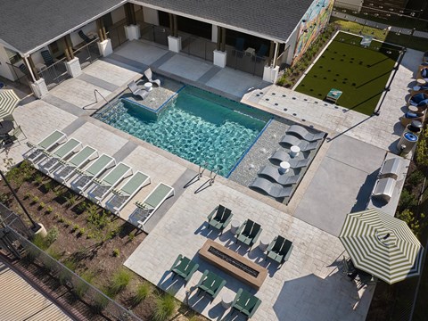 A pool with sun loungers and a table.