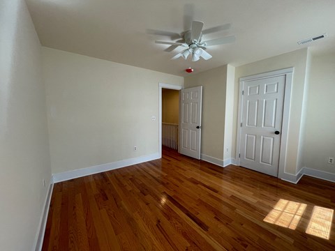 a living room with wood floors and a ceiling fan