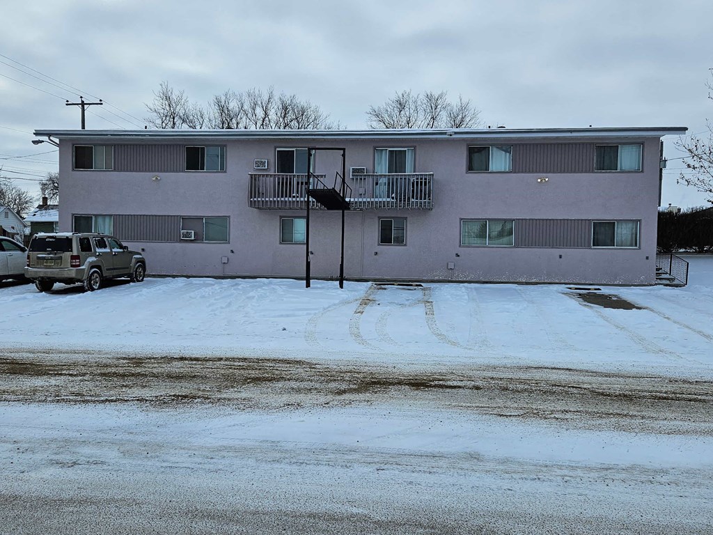 an apartment building with a car parked in front of it