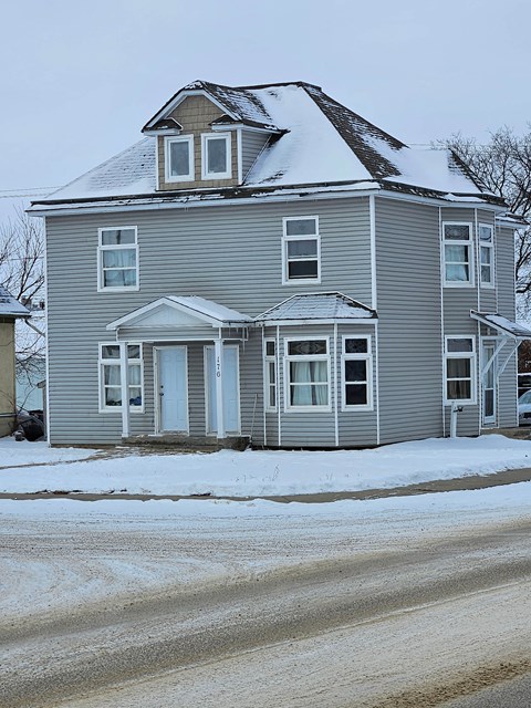 a gray house with snow on top of it