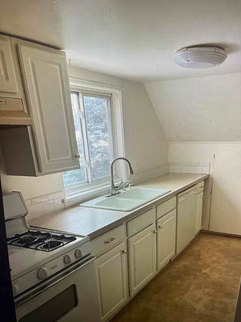 a kitchen with a sink and a stove and a window