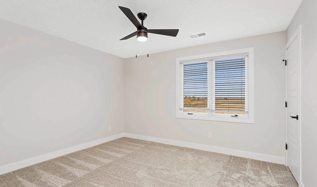 a bedroom with a window and a ceiling fan